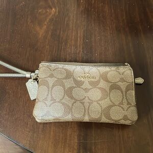Medium Coach wristlet. Good condition, no scratches,dark stain on one corner